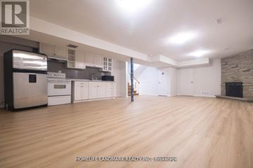 Toronto (Newtonbrook West) apartment for rent - A spacious kitchen with wooden floors and a brick accent wall.