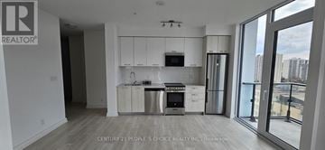 Hamilton (Corktown) townhouse for rent - A modern kitchen with white cabinets and stainless steel appliances.