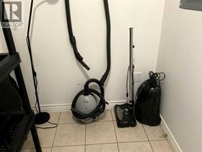 Lloydminster apartment for rent - A vacuum cleaner, a mop, and a bag of cleaning supplies are on the floor.