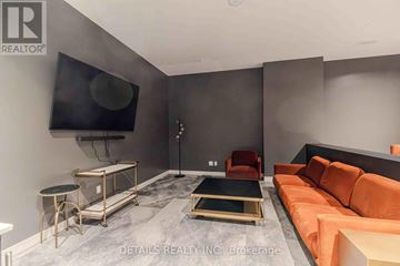 Ottawa condo for rent - A living room with a grey floor and a black television mounted on the wall.