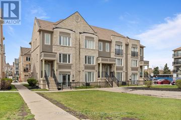 Mississauga (Churchill Meadows) townhouse for rent - Apartment building with a lawn in front and a clear blue sky.