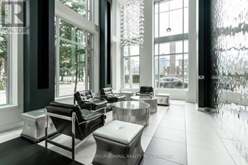 Toronto (Moss Park) townhouse for rent - A modern living room with black and white furniture and large windows.