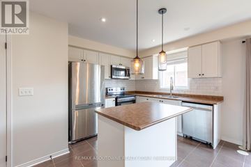 Oakville (Wm Westmount) townhouse for rent - A modern kitchen with a stainless steel refrigerator and a wooden island.