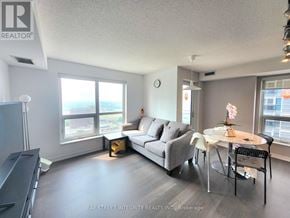 Toronto (Agincourt South-Malvern West) condo for rent - A living room with a grey couch, a white table, and a television.