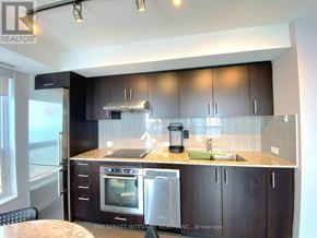 Toronto (Agincourt South-Malvern West) condo for rent - A kitchen with dark brown cabinets and stainless steel appliances.