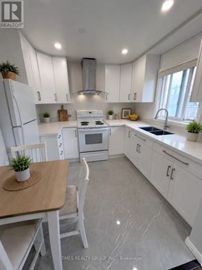 Toronto (Humbermede) apartment for rent - A white kitchen with a table and chairs.