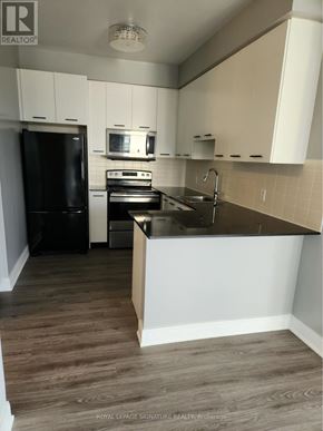 Toronto (Agincourt South-Malvern West) condo for rent - A kitchen with black appliances and white cabinets.