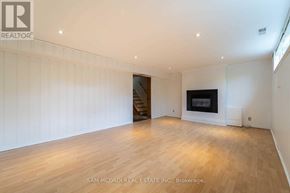 Mississauga (Clarkson) apartment for rent - A spacious room with wooden flooring and a fireplace.