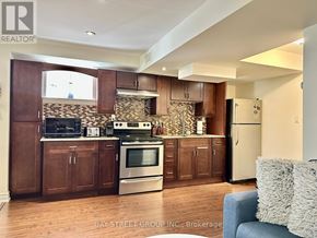 Richmond Hill (Oak Ridges Lake Wilcox) apartment for rent - A kitchen with wooden cabinets and a stone backsplash.