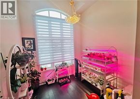 Hamilton apartment for rent - A room with a chandelier, a shelf with plants, and a grow light.