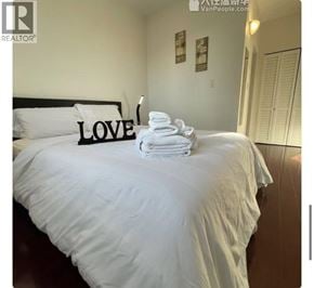 Richmond apartment for rent - A bed with white sheets and a black headboard with the word LOVE on it.