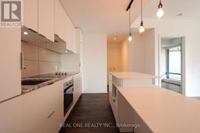 Toronto (Bay Street Corridor) condo for rent - A modern kitchen with white cabinets and a marble countertop.