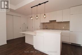 Toronto (Bay Street Corridor) condo for rent - A modern kitchen with white cabinets and a wooden floor.