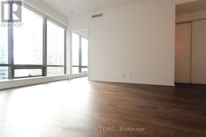 Toronto (Bay Street Corridor) condo for rent - A large, empty room with wooden floors and large windows.
