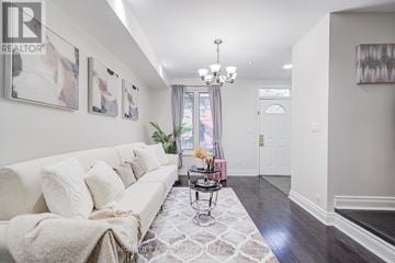 Toronto (Moss Park) townhouse for rent - A well-lit living room with a white sofa and a chandelier.