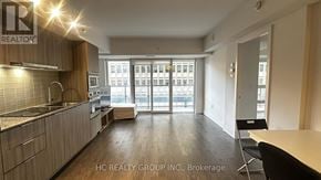 Toronto (Bay Street Corridor) condo for rent - A kitchen with a counter and chairs with a sign that says REALTOR.
