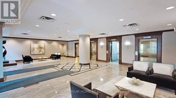Toronto (Newtonbrook East) condo for rent - A spacious living room with a black couch and a coffee table.