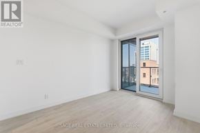 Hamilton (Corktown) condo for rent - A white room with a sliding glass door leading to a balcony.