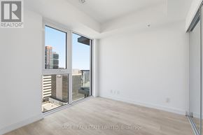 Hamilton (Corktown) condo for rent - A room with a view of a city skyline through large windows.