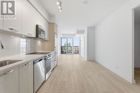 Hamilton (Corktown) condo for rent - A modern kitchen with stainless steel appliances and wooden cabinets.
