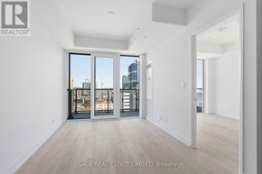 Hamilton (Corktown) condo for rent - A spacious room with a view of the city through large windows.