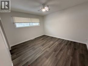 Lloydminster apartment for rent - A room with wooden flooring and a window with blinds.