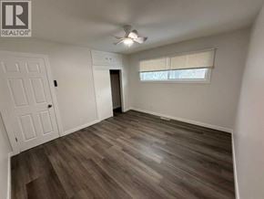 Lloydminster apartment for rent - A room with a wooden floor and a window with blinds.