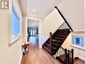 Mississauga (Lakeview) apartment for rent - A hallway with a staircase and a vase of flowers.