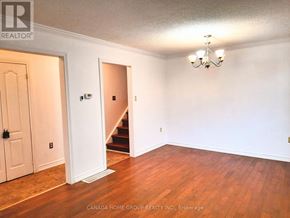 Barrie (Painswick North) apartment for rent - A room with a chandelier, a staircase, and a door.