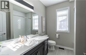 Kitchener apartment for rent - A bathroom with a sink, toilet, and a window.