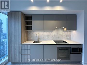 Toronto (Waterfront Communities) condo for rent - A modern kitchen with a stainless steel oven and a marble backsplash.