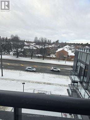 Toronto (Rouge) condo for rent - A view from a balcony looking out at a snowy street with cars parked on the side.