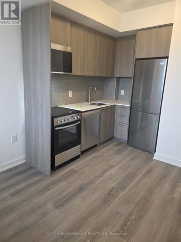Toronto (Rouge) condo for rent - A kitchen with wooden cabinets and a refrigerator.