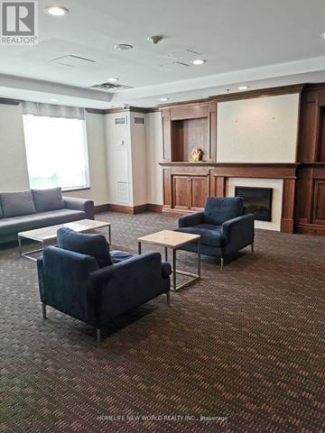 Richmond Hill (Langstaff) condo for rent - A living room with a grey sofa, a blue chair and a fireplace.