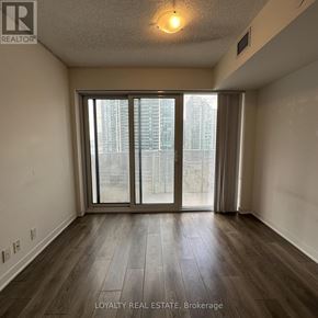 Toronto (Waterfront Communities) condo for rent - A room with a large window and wooden flooring.