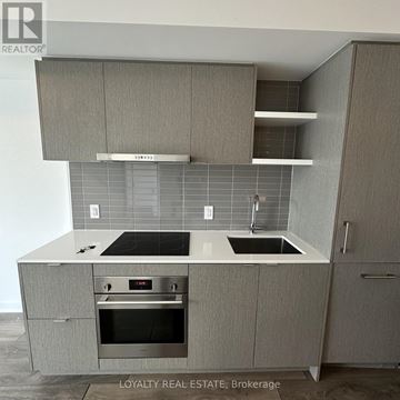 Toronto (Waterfront Communities) condo for rent - A modern kitchen with a stove top oven and a double sink.