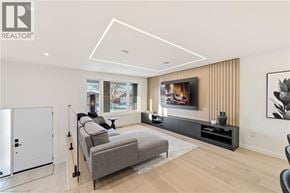 Hamilton apartment for rent - A modern living room with a grey sofa and a flat screen TV mounted on the wall.