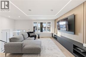 Hamilton apartment for rent - A modern living room with a grey sofa and a flat screen TV mounted on the wall.