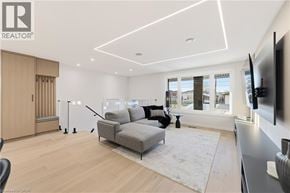 Hamilton apartment for rent - A modern living room with a grey sofa and a television on the wall.