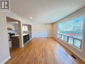 Ottawa multi-family for rent - A spacious room with wooden flooring and a large window overlooking a street.