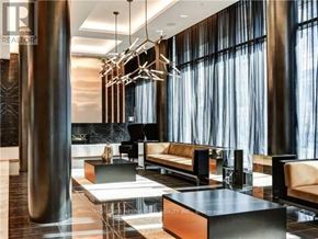 Toronto (Mount Pleasant West) condo for rent - A modern hotel lobby with a marble floor, a large window with curtains, and a seating area with a coffee table and chairs.