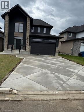 Stratford apartment for rent - A house with a black garage door is in front of a cloudy sky.