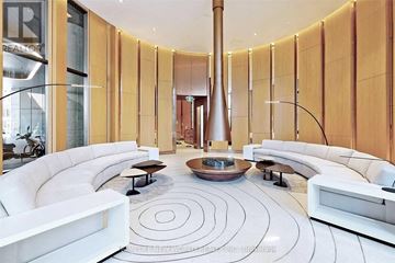 Toronto (Bay Street Corridor) condo for rent - A modern living room with a spiral rug and a large vase in the middle.