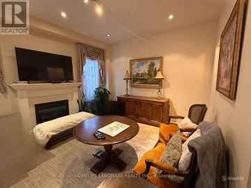 Vaughan (Vellore Village) apartment for rent - A living room with a fireplace, a television, a couch, and a painting on the wall.