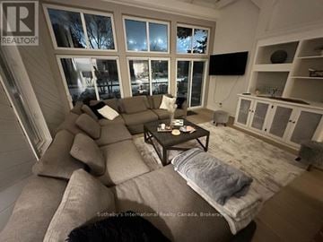 Blue Mountains apartment for rent - A living room with a large couch and a flat screen TV mounted on the wall.