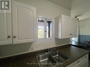 Belleville (Belleville Ward) fourplex for rent - A kitchen with white cabinets and a granite countertop.