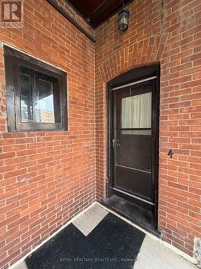 Belleville (Belleville Ward) fourplex for rent - A door with a window on the left and a black mat in front of it.
