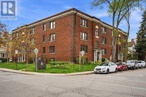 Hamilton (Stinson) condo for rent - A street view of a building with cars parked in front.