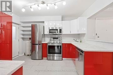 Hamilton (Stinson) condo for rent - A modern kitchen with red cabinets and stainless steel appliances.