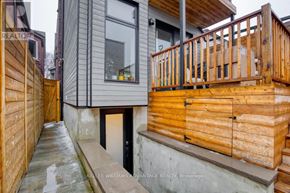 Toronto (Dovercourt-Wallace Emerson-Junction) apartment for rent - A wooden deck with a railing is in front of a house.